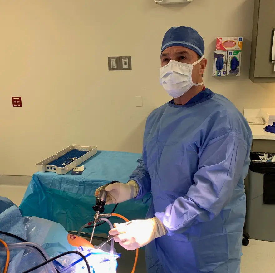 Dr. Rich Diana in surgical cap, mask and gown during an arthroscopic procedure.