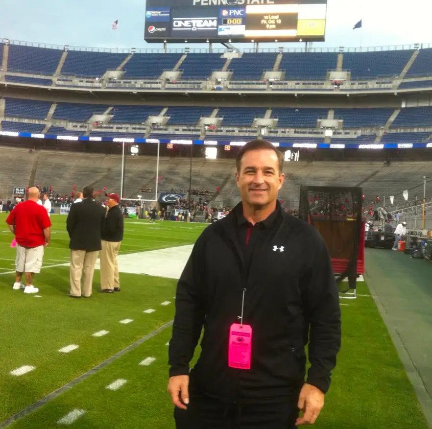 Dr. Rich Diana standing on a football field sideline.